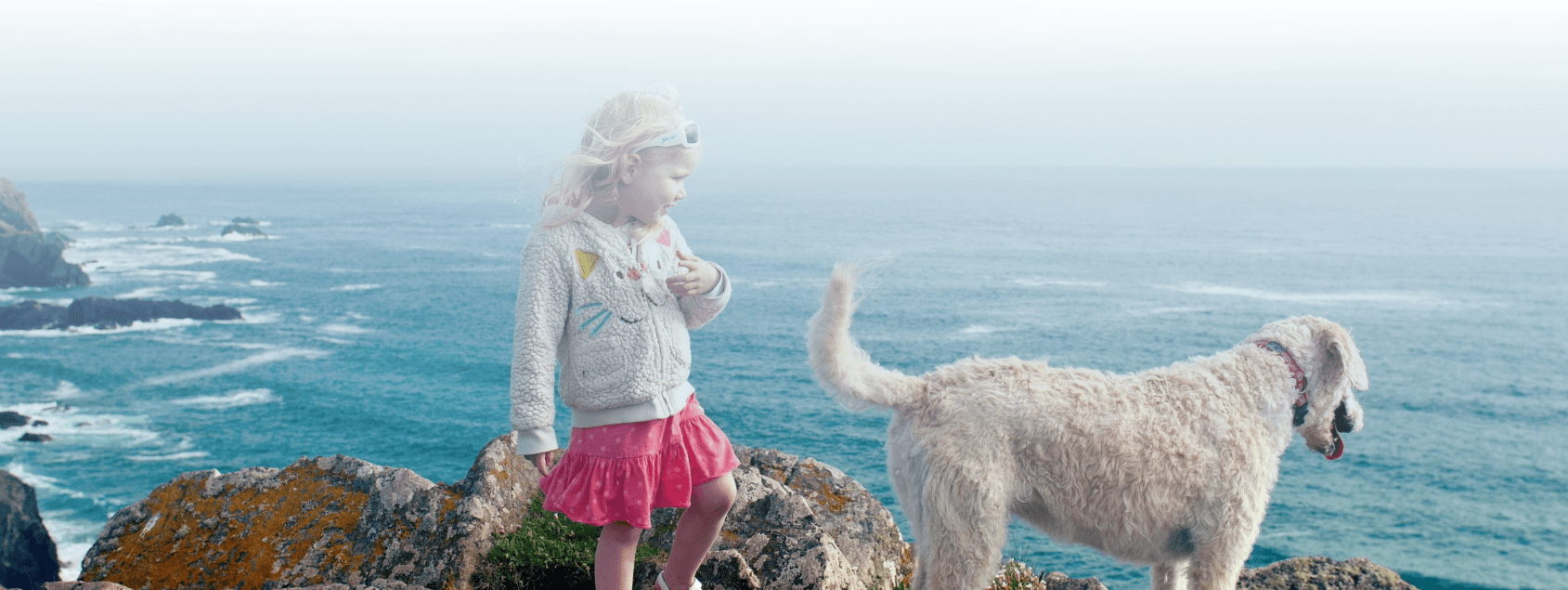 Nia pequea con su perro en la costa